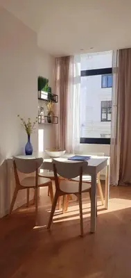 a table and two chairs in a room with a window at The South Suite - trendy duplex op het Zuid in Antwerp