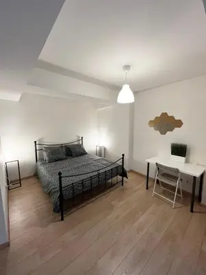 a bedroom with a bed and a table and a desk at Elegant flat - Center of Brussels in Brussels