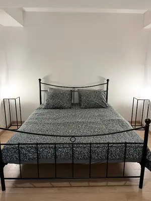 a bed with a black frame and two pillows at Elegant flat - Center of Brussels in Brussels