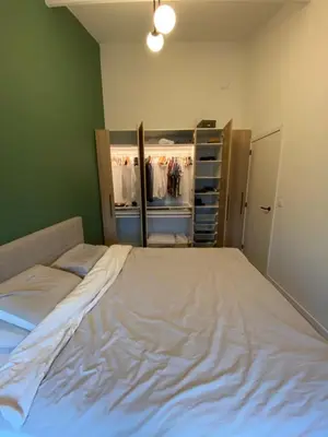 a large bed in a room with a closet at Luxury & cozy apartment in Lubbeek