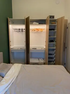 a bedroom with an open closet with a bed at Luxury & cozy apartment in Lubbeek