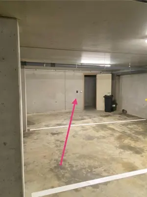 an empty room with a pink arrow pointing to a door at Luxury & cozy apartment in Lubbeek