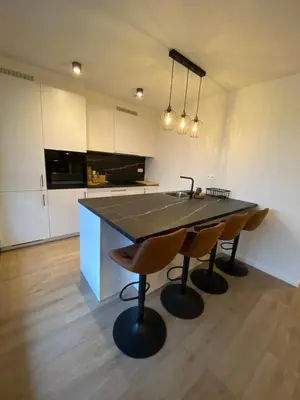 a kitchen with a table with two chairs and a sink at Luxury & cozy apartment in Lubbeek