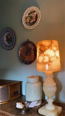 a table with a lamp and plates on the wall at Dilectus (Via Caput) in Lokeren