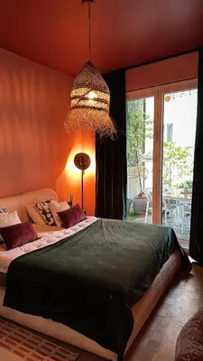 a bedroom with a large bed and a chandelier at Kleurrijke nieuwe woonst in hartje Antwerpen in Antwerp