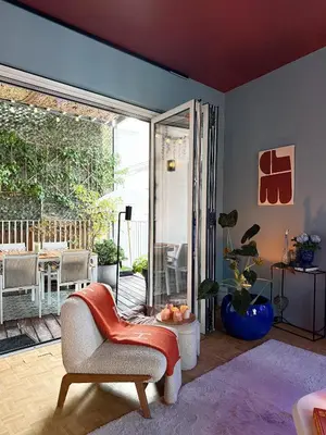 a living room with a chair and a sliding glass door at Kleurrijke nieuwe woonst in hartje Antwerpen in Antwerp