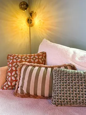 a group of pillows sitting on a bed with a lamp at Kleurrijke nieuwe woonst in hartje Antwerpen in Antwerp