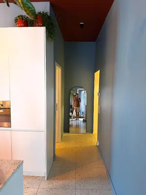 a hallway in a house with a person walking in the distance at Kleurrijke nieuwe woonst in hartje Antwerpen in Antwerp