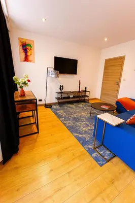 a living room with a blue couch and a tv at Brussels Sanctuary Appartment in Brussels