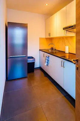 a kitchen with white cabinets and a stainless steel refrigerator at Brussels Sanctuary Appartment in Brussels
