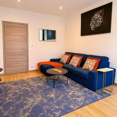 a living room with a blue couch with pillows at Brussels Sanctuary Appartment in Brussels