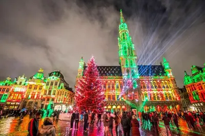 a christmas tree in front of a building with christmas lights at Appartement au cœur de Bruxelles in Brussels