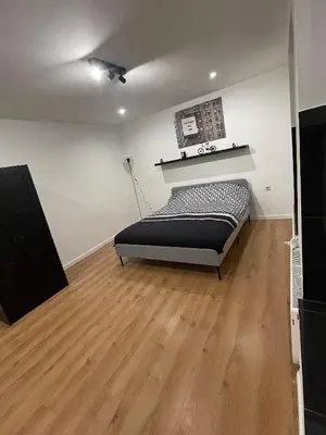 a bedroom with a bed on a wooden floor at Appartement au cœur de Bruxelles in Brussels