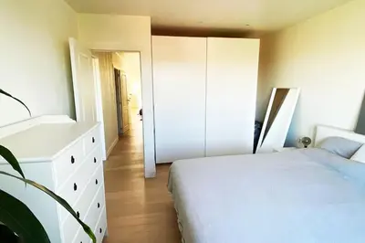 a bedroom with a white bed and a white dresser at Classy flat with awesome view and great location! in Antwerp