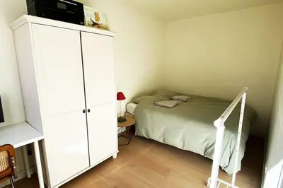 a bedroom with a bed and a white cabinet at Classy flat with awesome view and great location! in Antwerp
