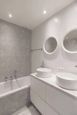 a white bathroom with two sinks and a bath tub at Classy flat with awesome view and great location! in Antwerp