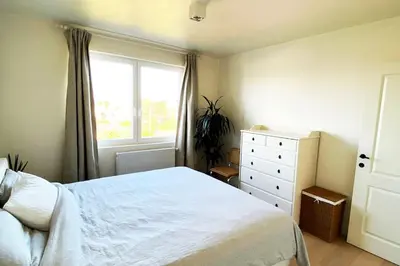 a bedroom with a white bed and a window at Classy flat with awesome view and great location! in Antwerp