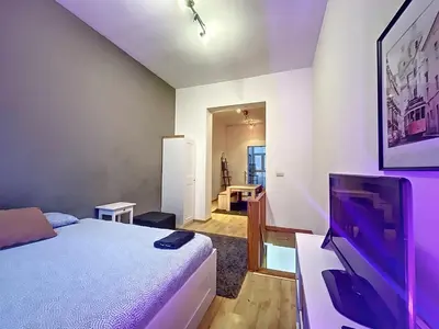 a bedroom with a bed and a flat screen tv at Family Stays Flagey in Brussels