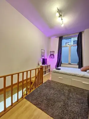 a bedroom with purple walls and a bed with a window at Family Stays Flagey in Brussels