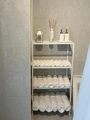 a bathroom with a towel rack with rolls of toilet paper at Appartement lumineux dans un quartier animé in Brussels