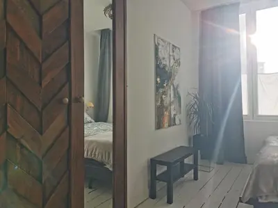 a door to a bedroom with a bed and a window at Cosy apartement in Antwerp's hipster neighbourhood in Antwerp