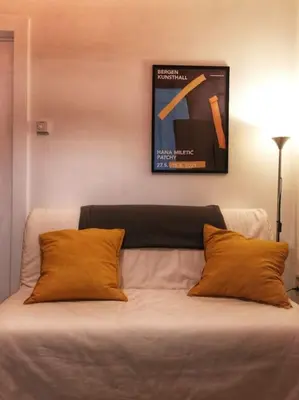 a bed with two pillows and a picture on the wall at Cosy apartement in Antwerp's hipster neighbourhood in Antwerp