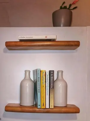 a shelf with three bottles and books and a remote control at Cosy apartement in Antwerp's hipster neighbourhood in Antwerp