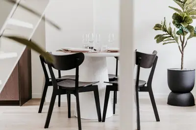 a dining room table with black chairs and a plant at Cathedral view from the bathtub in Antwerp