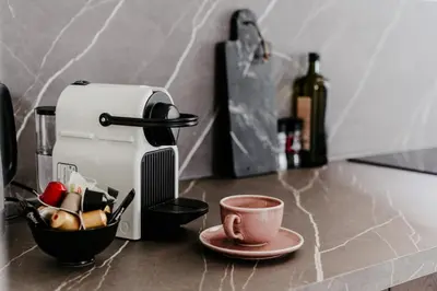 a cup of coffee on a counter next to a coffee maker at Cathedral view from the bathtub in Antwerp