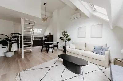 a living room with a white couch and a table at Cathedral view from the bathtub in Antwerp