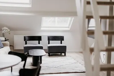 a living room with two chairs and a couch at Cathedral view from the bathtub in Antwerp