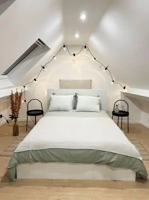 a bedroom with a large bed with lights above it at Magnifique duplex in Brussels