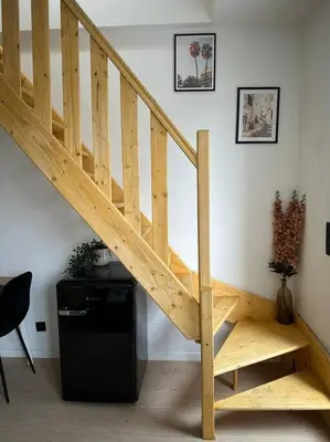 a wooden staircase in a room with a desk at Magnifique duplex in Brussels