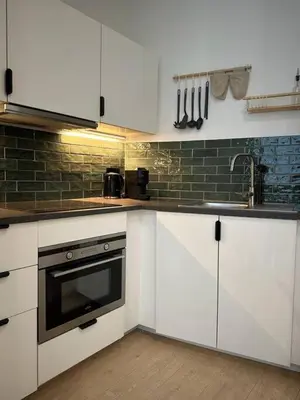 a kitchen with white cabinets and a sink at Magnifique duplex in Brussels