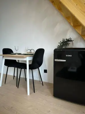 a table with two chairs and a table with a small refrigerator at Magnifique duplex in Brussels