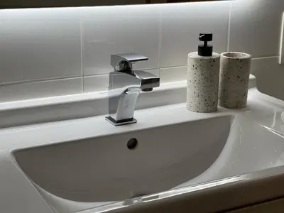 a bathroom sink with a faucet and two cups on it at Stunning apartment by MAS in Antwerp