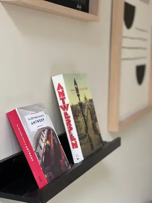 a shelf with two books and a mirror on it at Stunning apartment by MAS in Antwerp