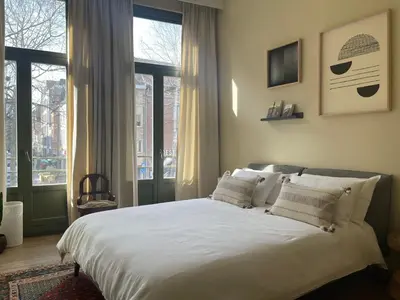 a bedroom with a large white bed with windows at Stunning apartment by MAS in Antwerp