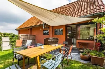 a table and chairs in front of a house at Ahwell Guesthouse Gent 5 BR long term in Laarne
