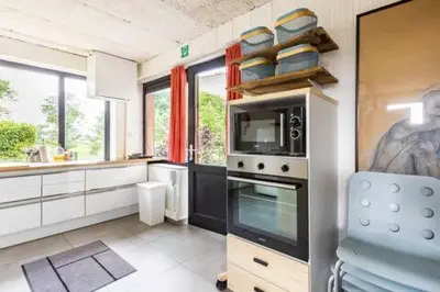 a kitchen with a stove and a microwave at Ahwell Guesthouse Gent 5 BR long term in Laarne