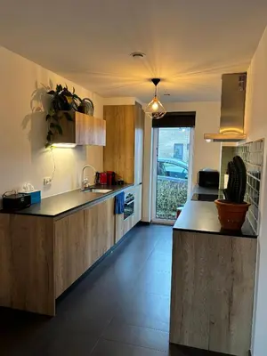 a kitchen with wooden cabinets and a counter top at Maison Seigneur in Asse