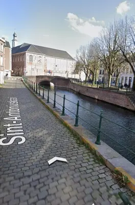 a brick road next to a river with a bridge at CES Home in Ghent