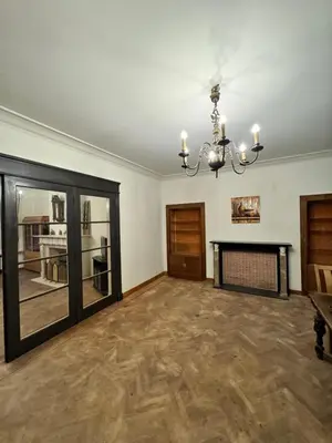 an empty living room with a chandelier and a fireplace at CES Home in Ghent