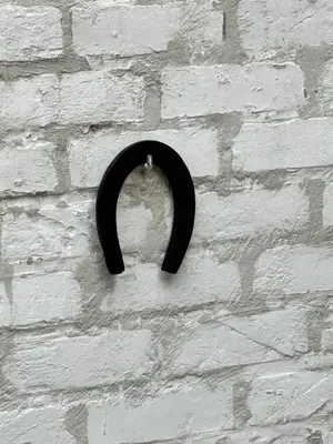 a black object is hanging on a brick wall at CES Home in Ghent