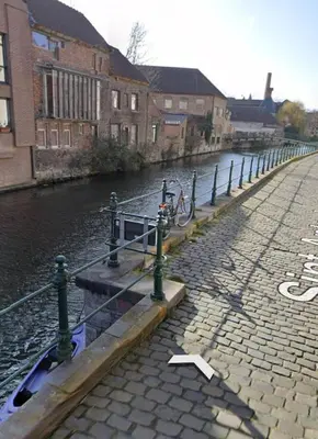 a bike is chained to a boat in a canal at CES Home in Ghent