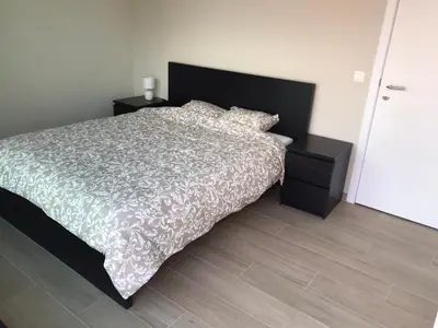 a bedroom with a large bed with a white comforter at Residentie Sluispark in Ghent