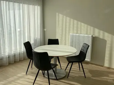 a dining room with a white table and black chairs at Residentie Sluispark in Ghent