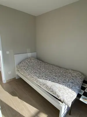 a small bedroom with a bed in the corner at Residentie Sluispark in Ghent