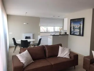 a living room with a couch and a table with chairs at Residentie Sluispark in Ghent