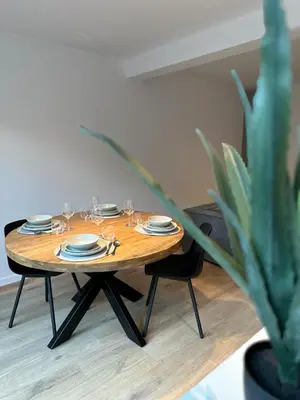 a wooden table with plates and glasses and a plant at Märch - Mechelen Goat 6 in Mechelen